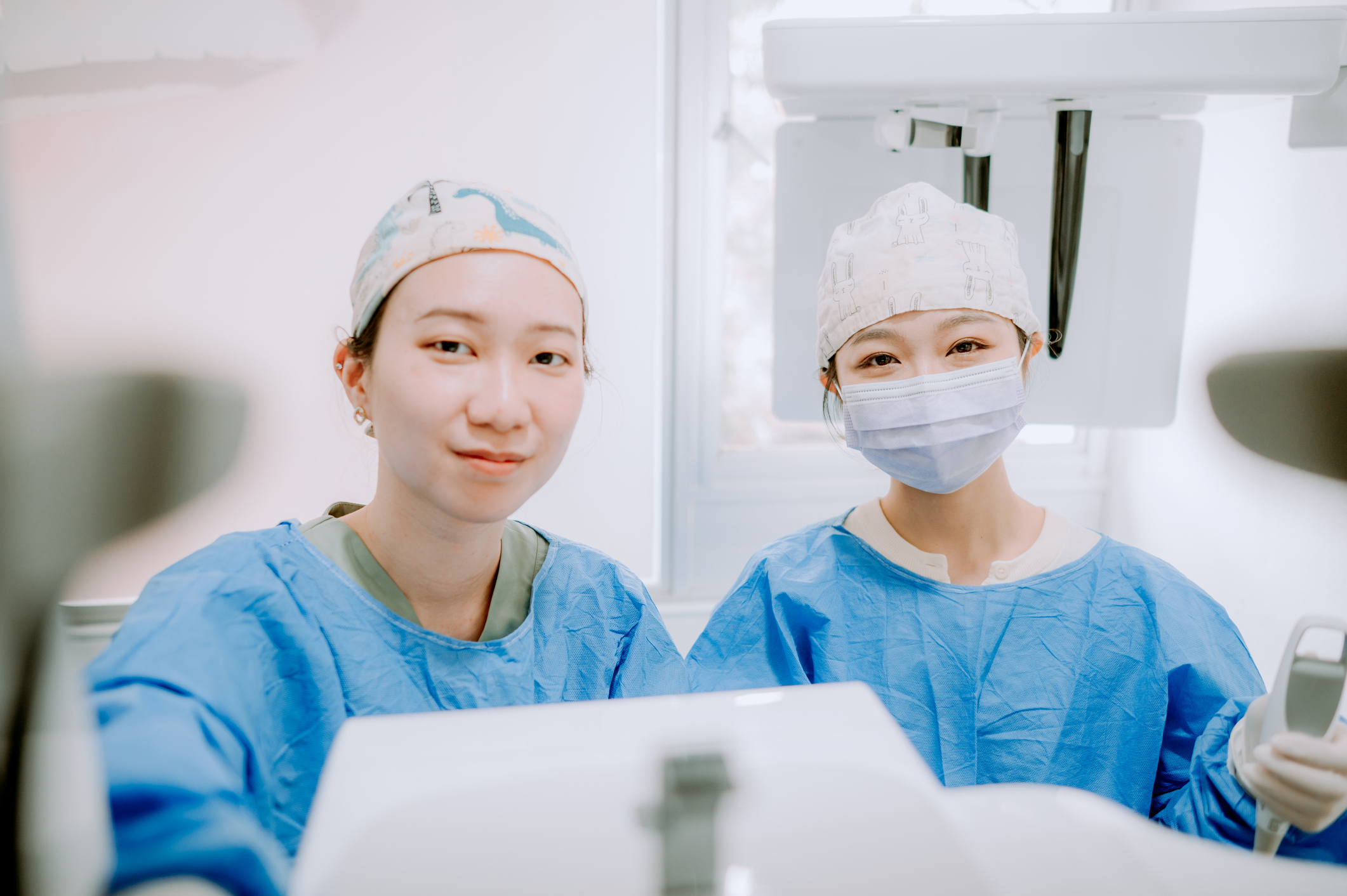 two asian chinese female dentists adjusting for x ray patient.
